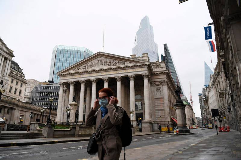 A pedestrian walks past the Bank of England and The Royal Exchange in the City of London on December 9, 2020.  Prime Minister Boris Johnson on Wednesday said a post-Brexit trade deal was still possible, as he prepared to head to Brussels to meet European Commission chief Ursula von der Leyen. / AFP / DANIEL LEAL-OLIVAS
