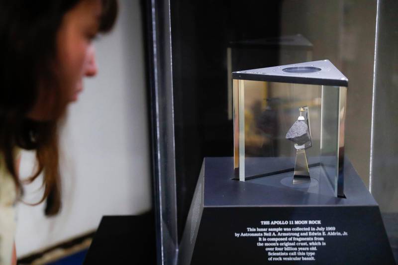 A moon rock is displayed within a glass case.