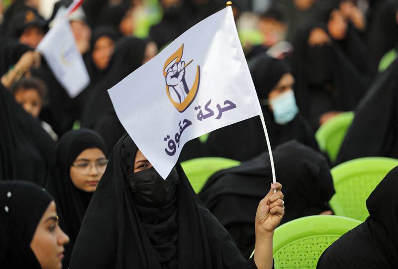 A woman holds a flag of the Huquq electoral list during a campaign rally in Baghdad. AFP