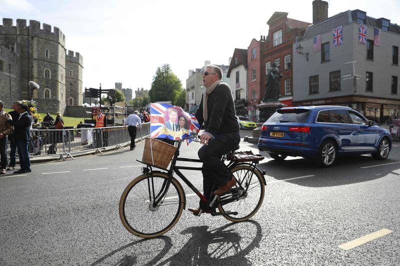 A man with a  souvenir flag rides a bicycle past Windsor Castle. Odd Andersen / AFP Photo