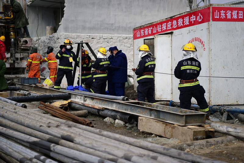 Members of a rescue team working at the site of a gold mine explosion where 22 miners are trapped underground in Qixia, in eastern China's Shandong province.  AFP