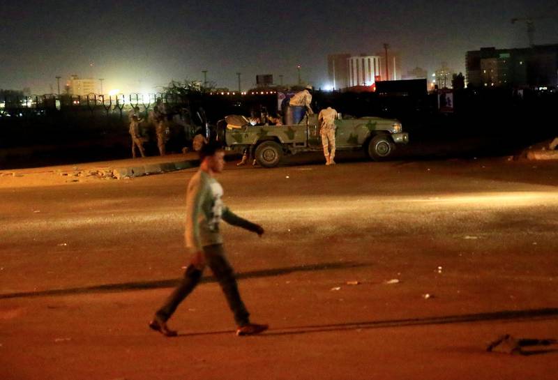 A civilian walks past members of the Sudanese Rapid Support Forces (RSF) are seen near the area where gunmen opened fire outside buildings used by Sudan's National Intelligence and Security Service (NISS) in Khartoum, Sudan January 14, 2020. REUTERS/Mohamed Nureldin Abdallah