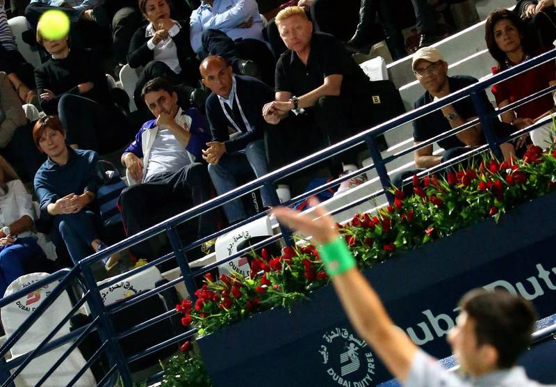 Boris Becker, top centre, looks on as Novak Djokovic serves against Roger Federer during their semi-final match at the Dubai Duty Free Tennis Championships on February 28, 2014. Marwan Naamani / AFP