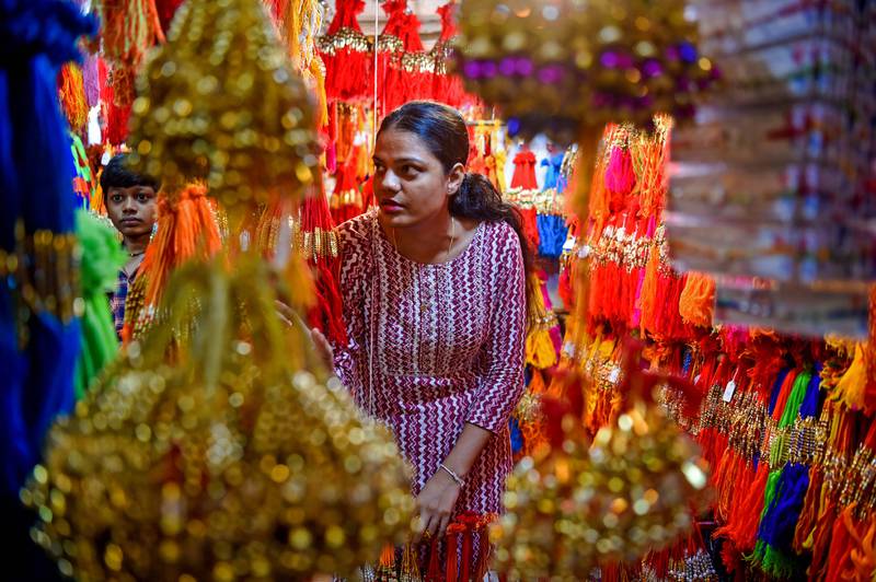 A woman shopkeeper speaks with customers at a roadside Rakhis' (amulets) stall ahead of the Hindu festival of Raksha Bandhan, in Mumbai on July 27, 2022.  (Photo by Punit PARANJPE  /  AFP)