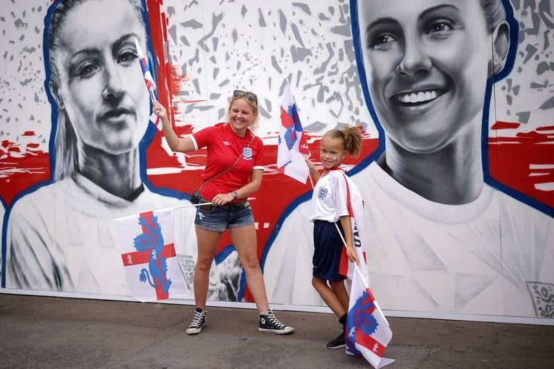 Fans pose for a photograph in front of a mural of Williamson at Trafalgar Square. Getty Images