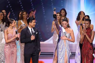 Hosts Olivia Culpo and Mario Lopez speak on stage with Miss Bolivia, Lenka Nemer, who won the Impact Award. Getty Images