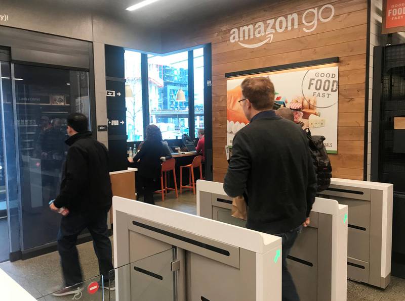 A customer walks out of the Amazon Go store, without needing to pay at a cash register due to cameras, sensors and other technology that track goods that shoppers remove from shelves and bill them automatically after they leave, in Seattle, Washington, U.S., January 18, 2018.  Photo taken January 18, 2018.   REUTERS/Jeffrey Dastin