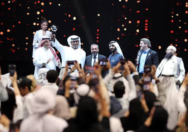 Ahmed Al Falasi lifts his trophy after being named the winner of the Arab Hope Makers award by Sheikh Mohammed bin Rashid. Chris Whiteoak / The National