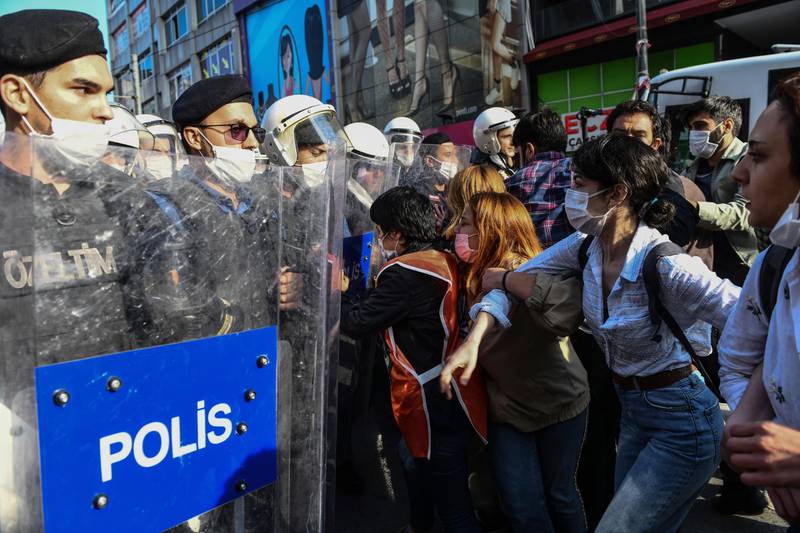 Turkish police officers in riot gear, and wearing face masks for protections against the spread of the coronavirus, scuffle with protesters during a demonstration in Istanbul, Tuesday, June 2, 2020, against the recent killing of George Floyd by police officers in Minneapolis, USA, that has led to protests in many countries and across the US. (AP Photo/Omer Kuscu)