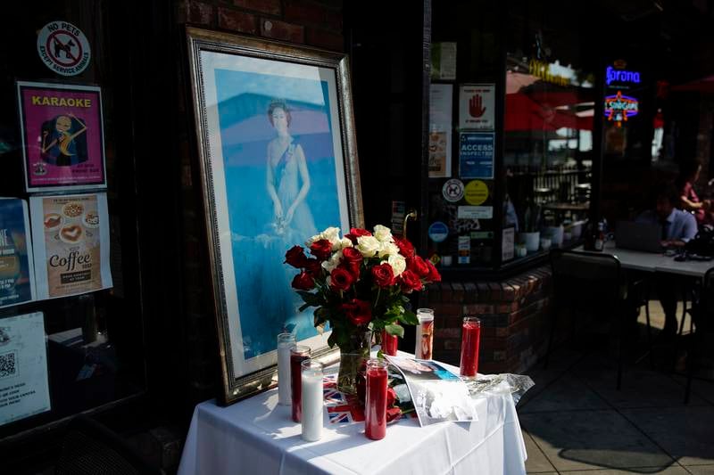 A memorial decorated with flowers, candles and photographs is set up at Ye Olde King's Head pub. EPA 