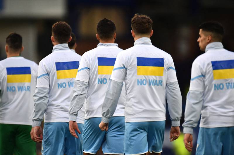 Manchester City footballers wear t-shirts in support of Ukraine before a match. Reuters