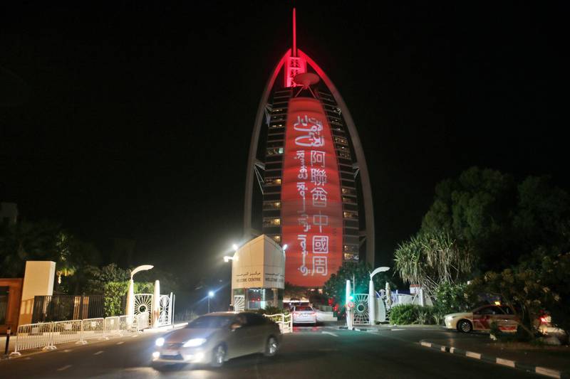 In this Wednesday, July 18, 2018 photo, a sign reading  "UAE Chinese Week" in Chinese and Arabic is projected  onto the Bus Al Arab luxury hotel to celebrate the UAE Chinese Week in Dubai, United Arab Emirates. Chinese President Xi Jinping is heading to Abu Dhabi in his first trip to the United Arab Emirates as the leader of China as the two countries look to strengthen trade ties and expand investment. (AP Photo/Kamran Jebreili)