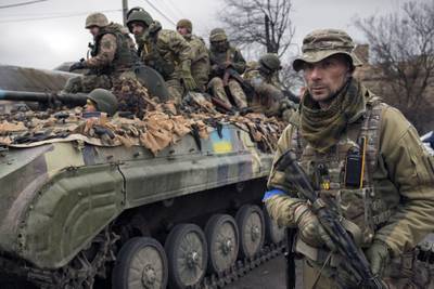 A Ukrainian soldier walks next to a military vehicle, outside Kyiv. AP
