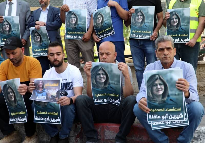 Palestinian journalists hold portraits of the Al Jazeera journalist.  EPA