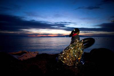 MYTELENE, GREECE - MARCH 09:  A small Syrian girl holds on to a rubber float during sunrise after arriving on an inflatable boat with other refugees, crossing the sea from Turkey to Lesbos, some 5 kilometres south of the capital of the Island, Mytelene on March 9, 2016 in Mytelene, Greece. During the night six inflatable baots reached the beaches of Lesbos. Joined Forces of the Standing NATO (North Atlantic Treaty Organisation) Maritime Group 2, including German Navy supply vessel "Bonn" have arrived at the coast of the greek Island of Lesbos today in order to patrol between the coast of Turkey and Greece. Turkey has announced today to take back illegal migrants from Syria and to exchange those with legal migrants.  (Photo by Alexander Koerner/Getty Images)
