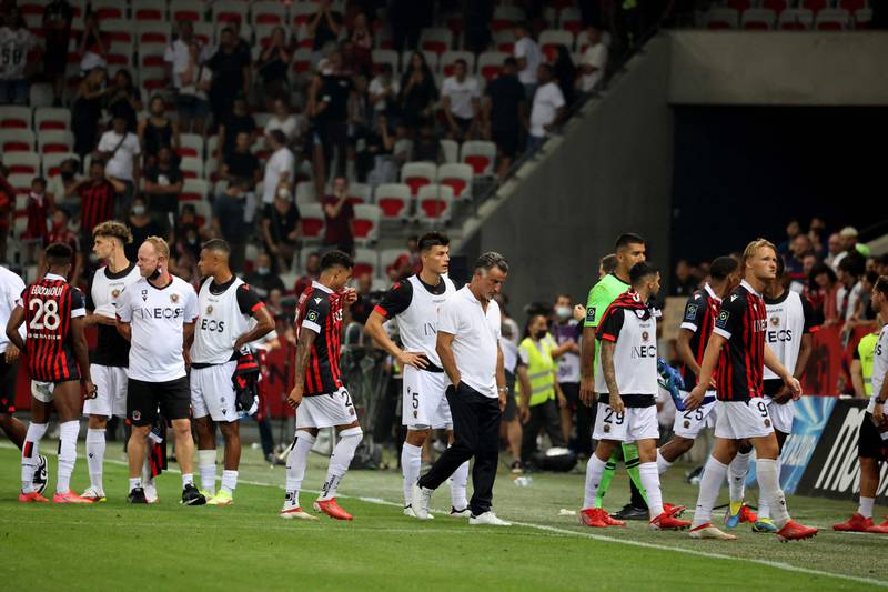 Nice's French coach Christophe Galtier (C) leaves the pitch with his players after the match is halted. AFP