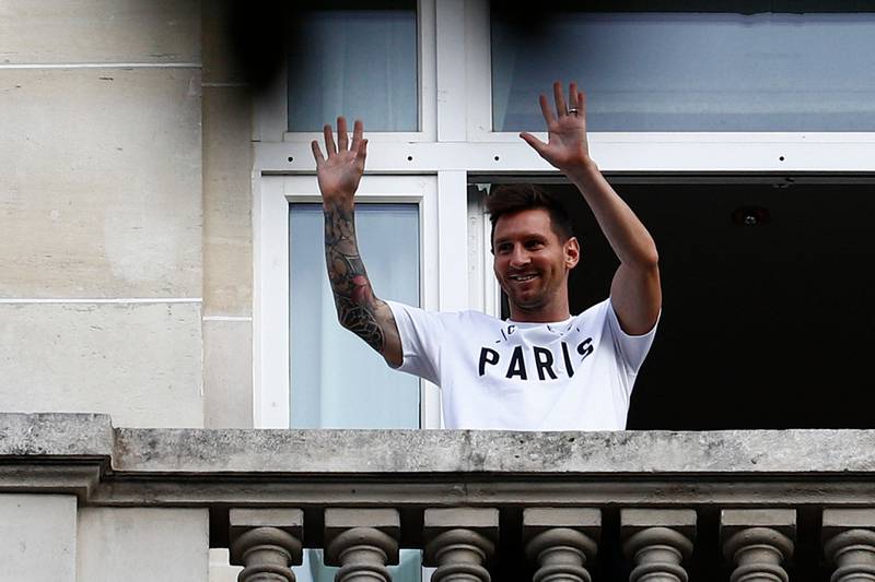Lionel Messi waves at fans from a balcony of the Royal Monceau hotel in Paris.