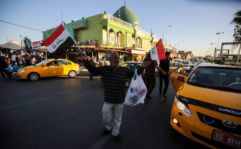 An Iraqi peddler sells Iraqi national flags amids traffic along a main street in the northern Iraqi city of Kirkuk, on October 17, 2017.
Iraqi forces seized the Kirkuk governor's office, key military sites and an oil field as they swept across the disputed province following soaring tensions over an independence referendum. / AFP PHOTO / AHMAD AL-RUBAYE