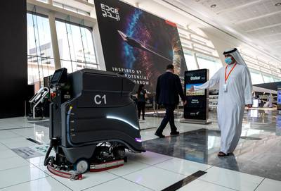 Abu Dhabi, United Arab Emirates, February 21, 2021.  Idex 2021, the first major in-person exhibition held in Abu Dhabi since the start of the Covid-19 pandemic, opened its doors to delegates on Sunday morning.  A visitor checks out a robot mopping the floor.Victor Besa / The NationalSection:  NAReporter:  John Dennehy