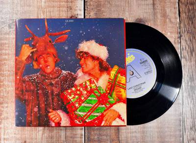 R18JP7 Last Christmas - WHAM 7inch single on a wooden background produced in 1984 George Michael