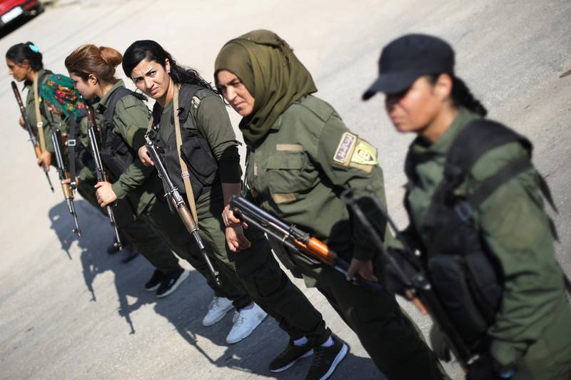 Kurdish policewomen stand guard as Kurdish and Arab protesters take part in a march against Turkish President and walk to the United Nations Headquarters in the town of Qamishli, Syria. REUTERS
