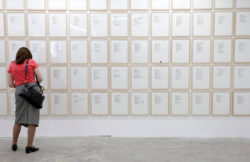 A visitor looks at rewritten pages by the artist Vladimir Miladinovic of the war time diary of former Bosnian Serb general Ratko Mladic in Belgrade, Serbia, July 1, 2020. EPA
