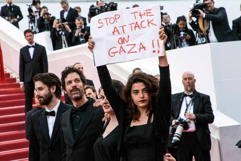 Lebanese actress Manal Issa, from "My Favorite Fabric," right, holds a sign that reads "Stop the Attack on Gaza" at the premiere of the film "Solo: A Star Wars Story" at the 71st international film festival, Cannes, southern France, Tuesday, May 15, 2018. Israeli soldiers shot and killed 59 Palestinians and wounded hundreds in mass protests on the Gaza border on Monday. Also with Issa are filmmakers Etienne Kallos, second left, and Gaya Jiji, second right. (Photo by Vianney Le Caer/Invision/AP)