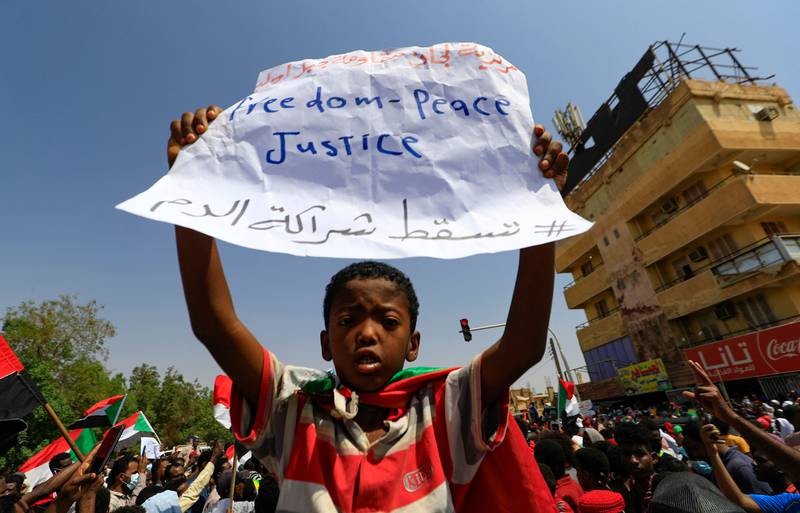 A young Sudanese demonstrator lifts a placard as protesters take to the streets of the capital Khartoum to demand a transition to civilian rule. All photos: AFP