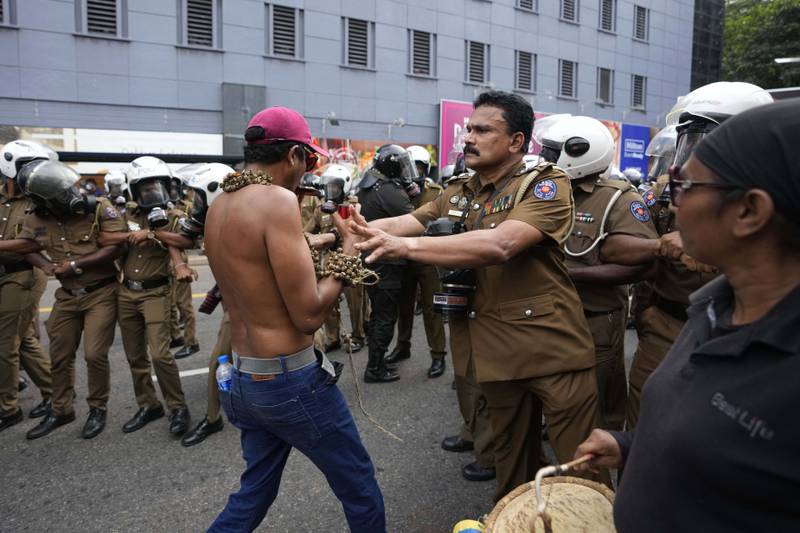 A police officer pushes a protester. AP