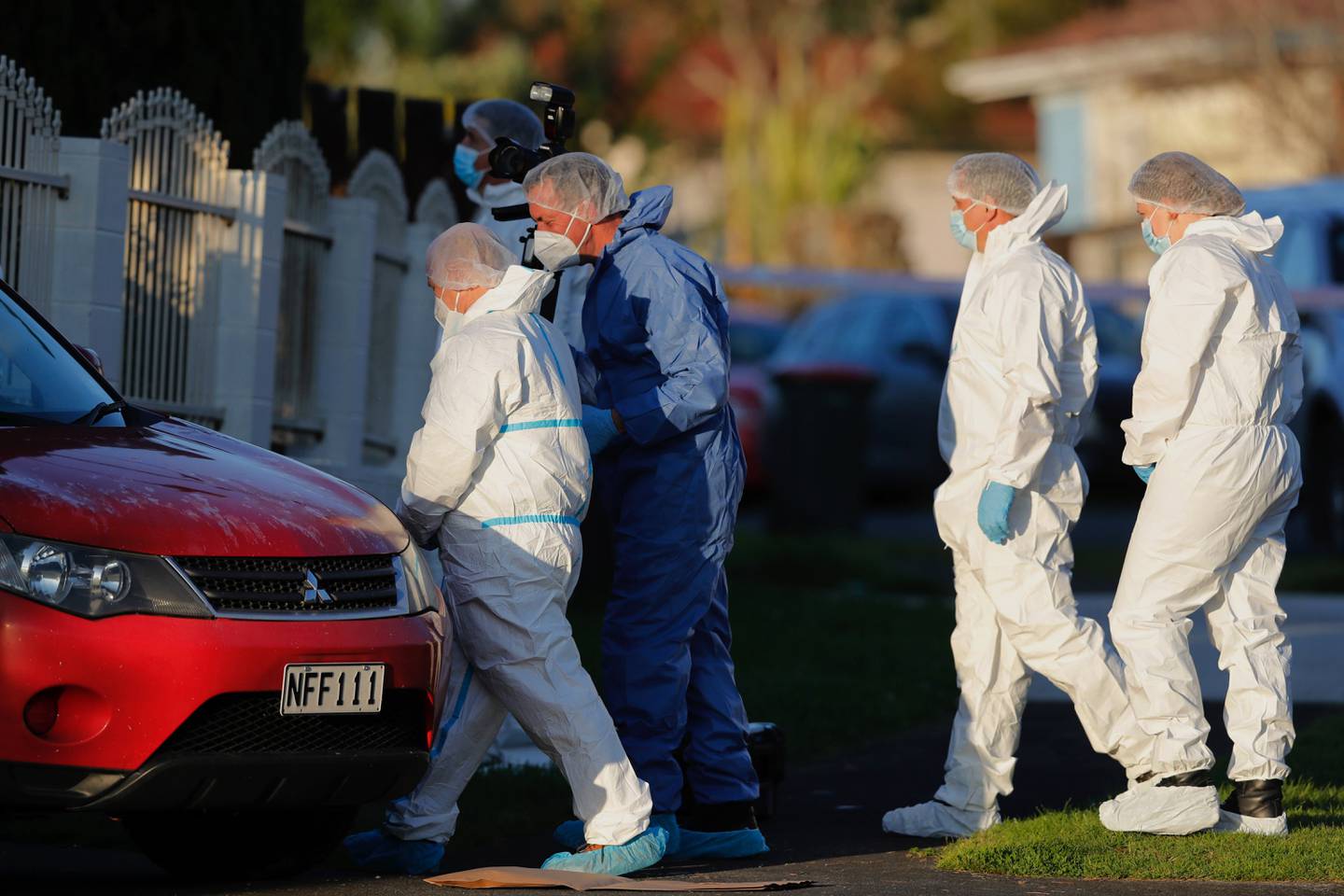 New Zealand police investigators work at a scene in Auckland on August 11 after bodies were discovered in suitcases. AP