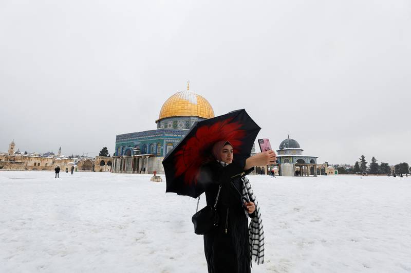 A woman takes a selfie in front of the Dome of the Rock, on the compound known to Muslims as Noble Sanctuary and to Jews as Temple Mount on a snowy morning in Jerusalem's Old City. Reuters