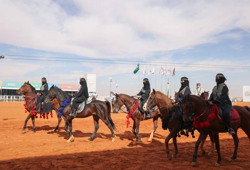 Women parade on horseback at the festival.