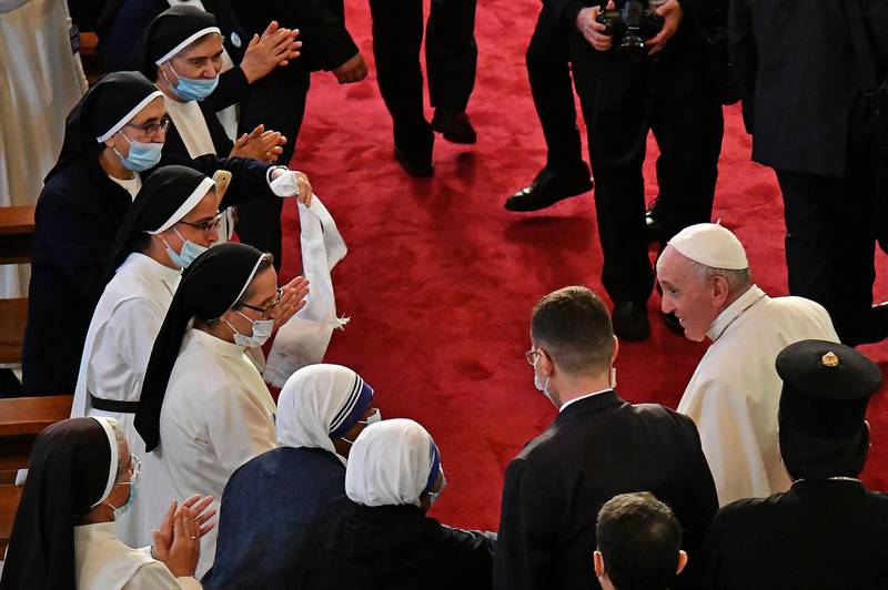 Nuns welcome Pope Francis at the Our Lady of Salvation Church. AFP