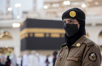 A Saudi policewoman, Samar, stands in front of the Kaaba.