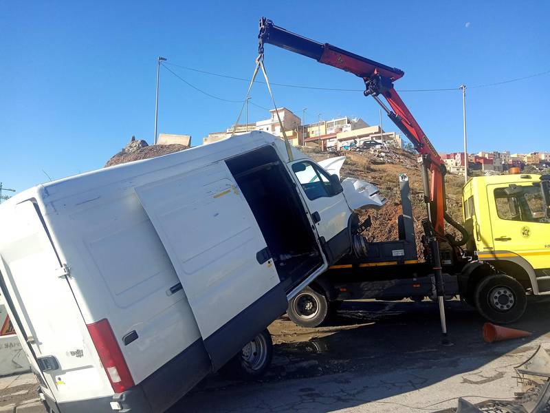 epa08005487 A crane removes the van that managed to enter in Spain with 52 migrants on board, after rushing at Tarajal border crossing, in Ceuta, Spanish enclave in northern Africa, 18 November 2019. The vehicle, with 14 men, 16 women and two children on board, broke the border's gates to reach Spain.  EPA/Reduan