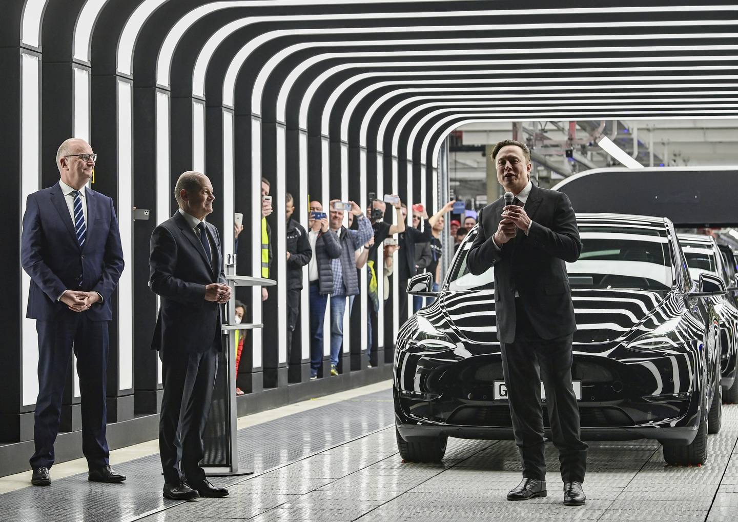 (L-R) Dietmar Woidke, Minister President of the State of Brandenburg, German Chancellor Olaf Scholz and Elon Musk attend the opening of the Tesla factory in Gruenheide, Germany. AP