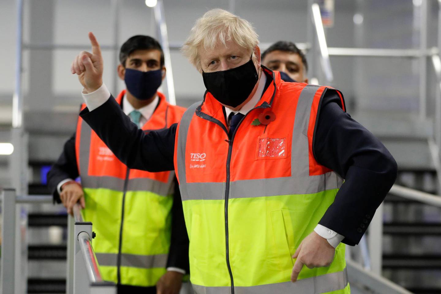 FILE - In this Nov. 11, 2020 file photo Britain's Prime Minister Boris Johnson, and Chancellor Rishi Sunak during a visit to a tesco.com distribution centre in London. Johnson is self-isolating after being told he came into contact with someone who tested positive for the coronavirus, officials said Sunday Nov. 15. "He will carry on working from Downing Street, including on leading the government's response to the coronavirus pandemic," a statement from his office said. (AP Photo/Kirsty Wigglesworth, File)