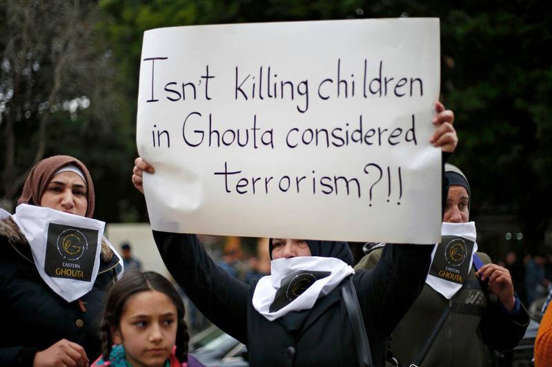 A Lebanese woman holds a placard during a protest in solidarity with residents of the Syrian capital's eastern suburb of Ghouta, in front the Russian embassy in Beirut, Lebanon, Sunday, Feb. 25, 2018. The Syrian capital and its embattled eastern suburbs were relatively calm on Sunday, following the U.N. Security Council's unanimous approval of a resolution demanding a 30-day cease-fire across Syria, opposition activists and residents of Damascus said. (AP Photo/Bilal Hussein)