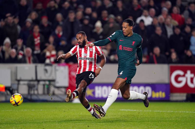 Brentford attacker Bryan Mbeumo shoots at goal under pressure from Liverpool's Virgil van Dijk. PA