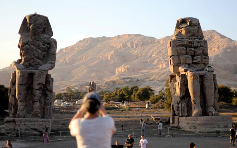 Tourists visit the Colossi of Memnon, the ruins of two stone statues that guarded the mortuary temple built for Pharaoh Amenhotep III, in Luxor, Egypt November 25, 2018. REUTERS/Mohamed Abd El Ghany