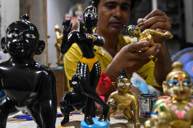 An artist applies finishing touches to an idol of Krishna at a workshop in Amritsar. AFP