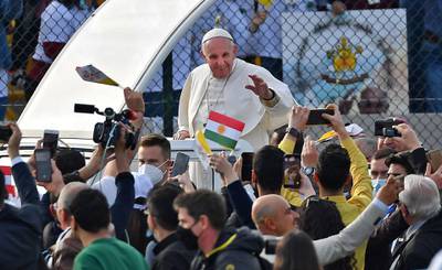Pope Francis blesses people as he arrives in the popemobile vehicle at the Franso Hariri Stadium in Erbil. AFP