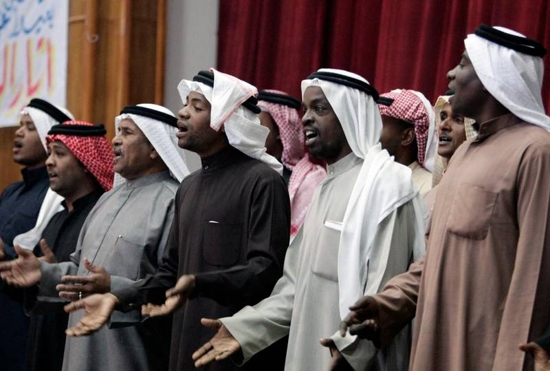 African-Iraqi men sing after their group "Free Iraqi Movement" was approved as a political party to run in the coming local elections in Basra, 420 km (260 miles) southeast of Baghdad December 6, 2008. Inspired by Barack Obama's election in the United States, some black Iraqis plan to run in a forthcoming election, to end what they call centuries of discrimination because of their slave ancestry.  Picture taken December 6.  To match feature IRAQ/BLACKS     REUTERS/Atef Hassan (IRAQ)