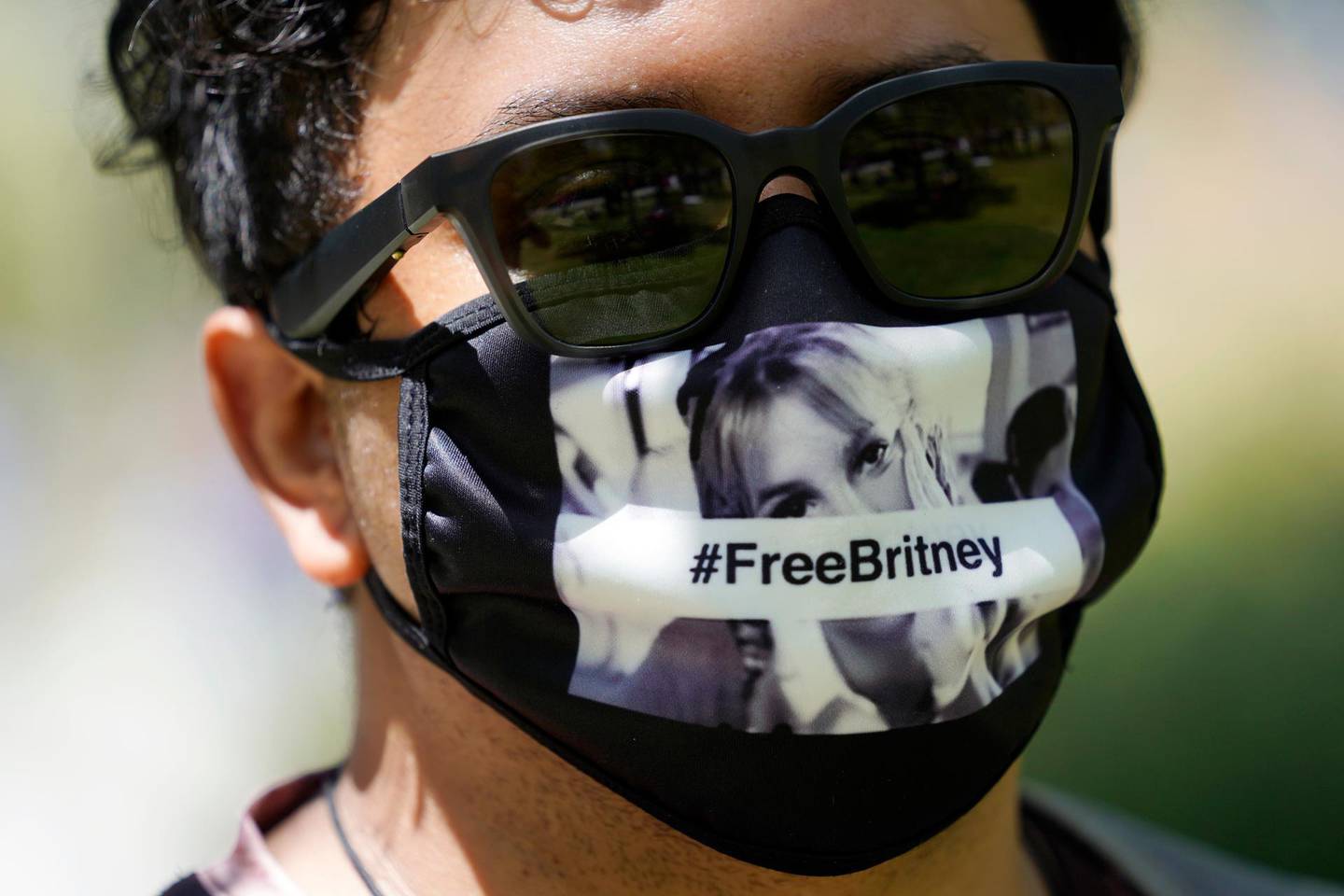 Britney Spears supporter Carlos Morales of Los Angeles wears a Free Britney mask outside a court hearing concerning the pop singer's conservatorship at the Stanley Mosk Courthouse, Wednesday, June 23, 2021, in Los Angeles. (AP Photo/Chris Pizzello)