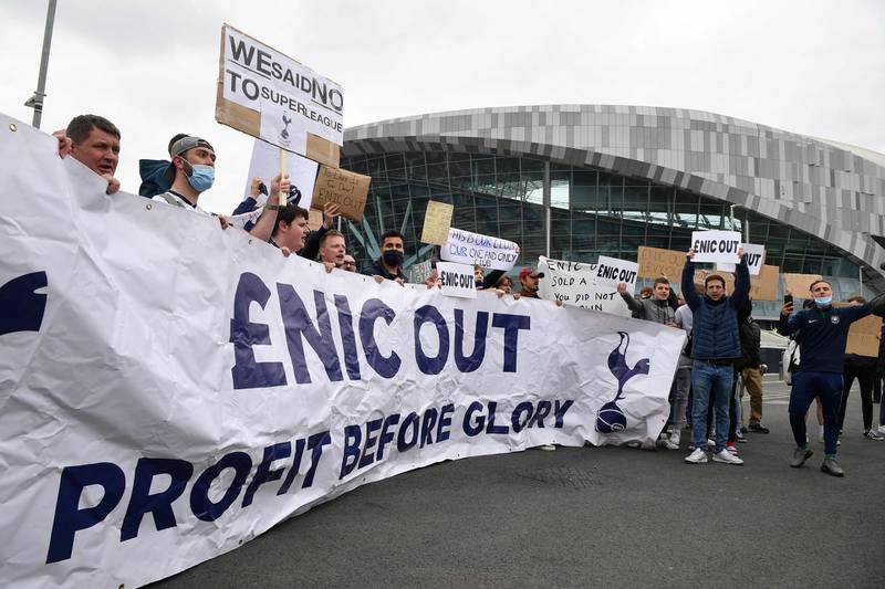 Fans carry posters and banners saying 'Enic out, profit before glory'. AFP