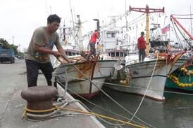 Fishermen fasten their boats as Typhoon Mawar approaches Taiwan's Yilan County. AP