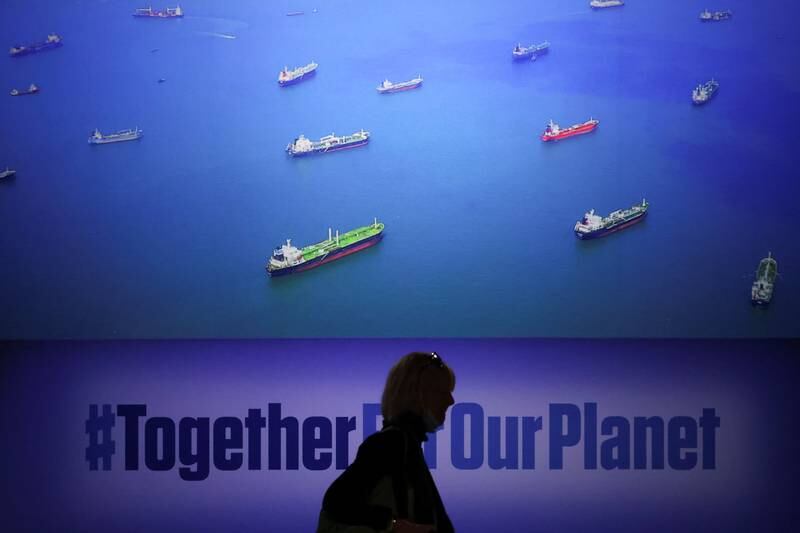 A visitor is silhouetted against a screen depicting shipping at the Cop26 summit. Reuters