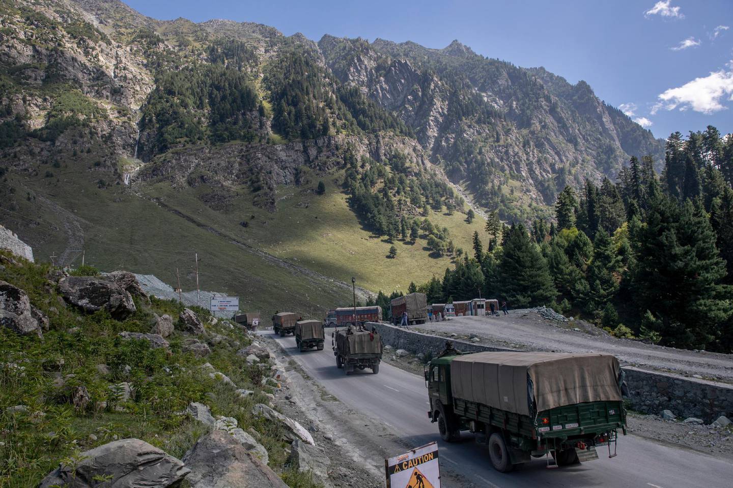 FILE - In this Sept. 9, 2020, file photo, an Indian army convoy moves on the Srinagar- Ladakh highway at Gagangeer, northeast of Srinagar, Indian-controlled Kashmir. The Indian military said it apprehended a Chinese soldier Monday, Oct. 19, in the remote Ladakh region, where the two countries are locked in a monthslong military standoff along their disputed border. (AP Photo/ Dar Yasin, File)