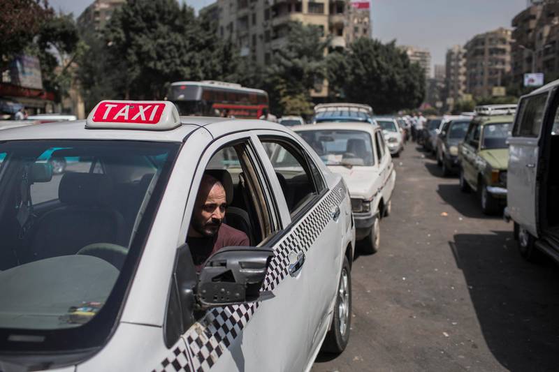 FILE - In this Sept. 4 2014 file photo, a taxi driver waits in line for fuel at a gas station in Cairo's neighboring city of Giza, Egypt. Egypt's parliament approved a law to govern popular ride-hailing apps Uber and Careem, which had faced legal challenges. The new law, as described Monday, May 7, 2018, by state news agency MENA, establishes operating licenses and fees. It requires licensed companies to store user data for 180 days and provide it to Egyptian security authorities upon request. (AP Photo/Eman Helal, File)
