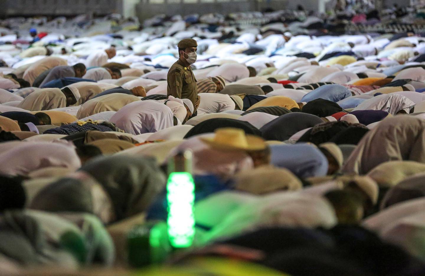 A Saudi security officer stands amongst Muslim worshippers as they perform prayers around the Kaaba, Islam's holiest shrine, at the Grand Mosque in Saudi Arabia's holy city of Mecca on August 17, 2018 prior to the start of the annual Hajj pilgrimage in the holy city. - Muslims from across the world are gathering in Mecca in Saudi Arabia for the annual hajj pilgrimage, one of the five pillars of Islam. (Photo by AHMAD AL-RUBAYE / AFP)